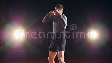 一个拳击手在<strong>黑</strong>暗的<strong>背景</strong>下<strong>炫</strong>耀他的拳击和踢腿。